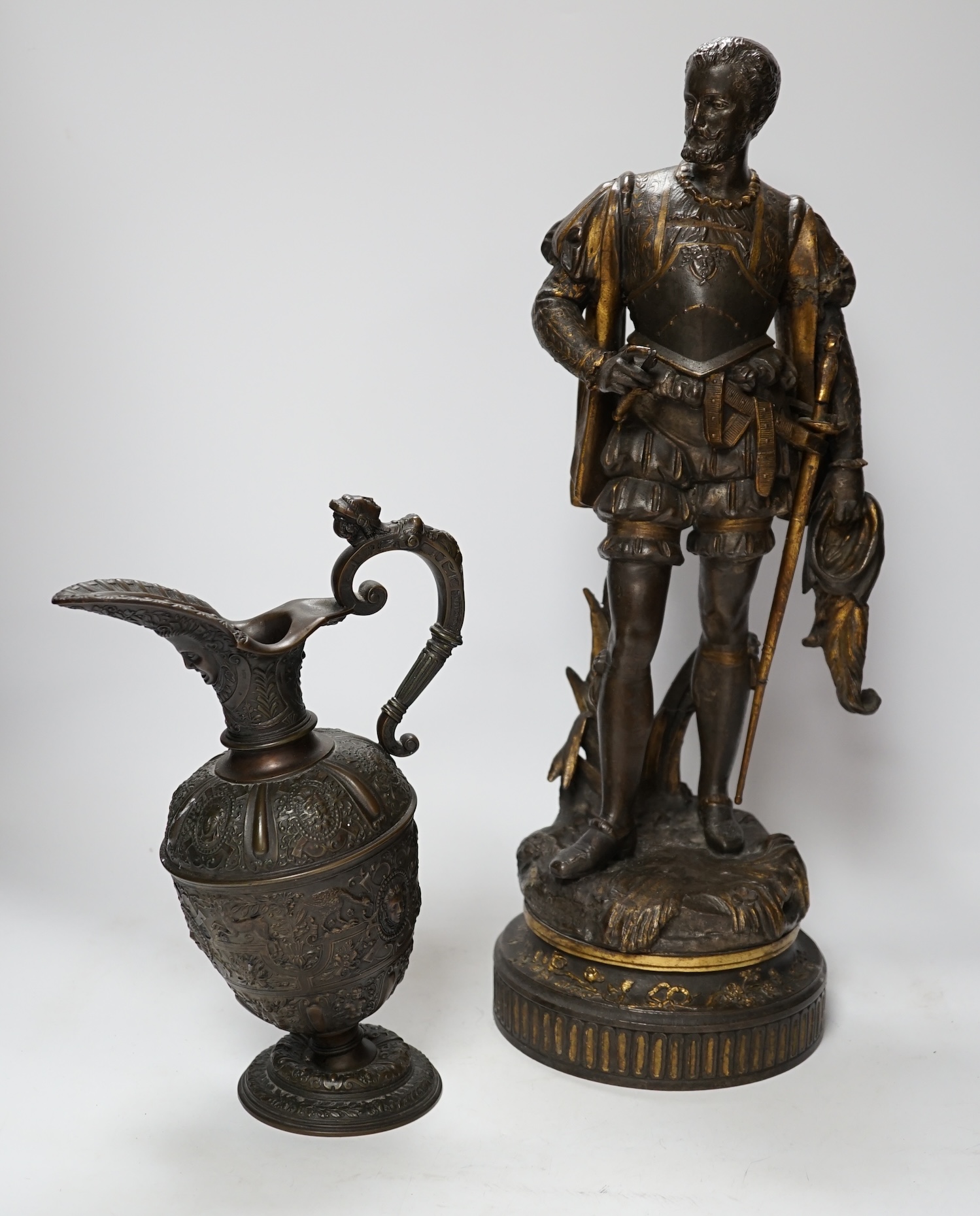 A 19th century parcel gilt and bronzed spelter figure of a cavalier, together with a Florentine style bronze ewer, 49cm high (the latter a.f.) (2)